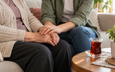 A younger relative holding an older adult's hand.